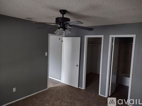 Tyler apartment for rent - A room with a ceiling fan and three doors.