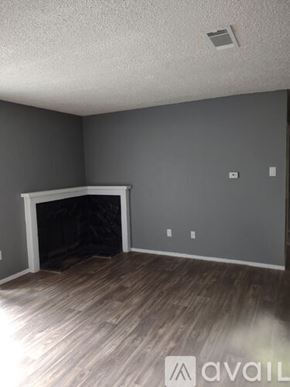 Tyler apartment for rent - A room with a fireplace and wooden flooring.