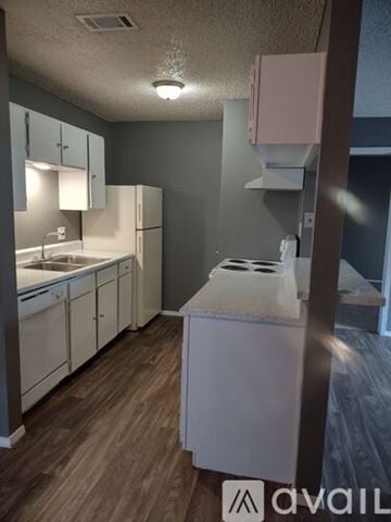 Tyler apartment for rent - A kitchen with white appliances and wooden floors.