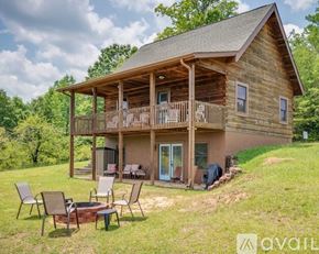 Mill Spring house for rent - A wooden cabin with a porch and a fire pit in front.
