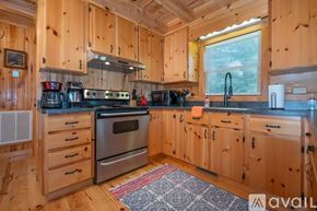 Mill Spring house for rent - A kitchen with wooden cabinets and a stove top oven.