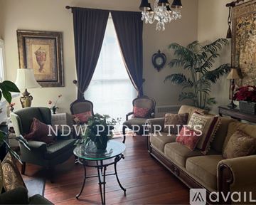 Wilson apartment for rent - A living room with a glass table and a sofa.