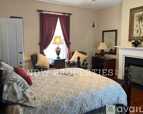 Wilson apartment for rent - A bedroom with a large bed and a fireplace.