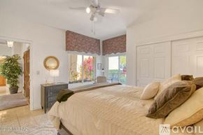 Oro Valley townhouse for rent - A bedroom with a large bed and a ceiling fan.