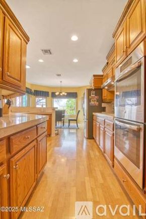 Oro Valley townhouse for rent - A kitchen with wooden cabinets and a refrigerator.