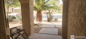 Maricopa house for rent - A patio with a chair and a view of a street with cars and palm trees.