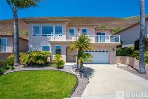Pismo Beach house for rent - A house with a garage and palm trees in front.