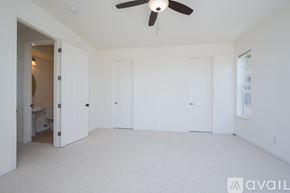 Pismo Beach house for rent - A spacious room with a ceiling fan and three doors.