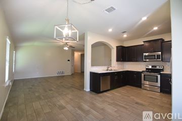 Temple house for rent - A kitchen with dark brown cabinets and a black countertop.