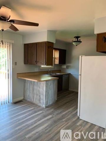 Newburgh house for rent - A kitchen with a white refrigerator and wooden cabinets.