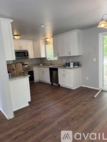 Olympia house for rent - A kitchen with white cabinets and a wooden floor.