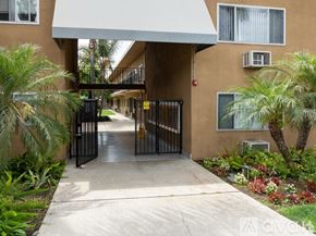 Azusa apartment for rent - A gated entrance to a building with a white awning and a concrete pathway.