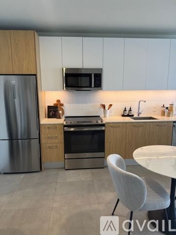Miami apartment for rent - A modern kitchen with a refrigerator, oven, and a microwave mounted above the stove.