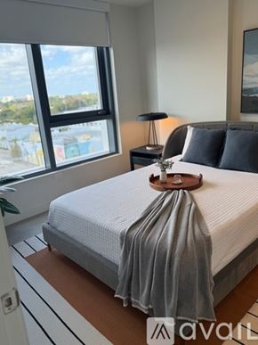Miami apartment for rent - A bedroom with a neatly made bed and a large window.