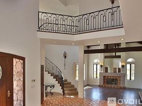 Westlake Village house for rent - A large open living room with a staircase and a fireplace.
