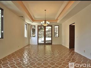 Westlake Village house for rent - A spacious room with a tiled floor and a chandelier hanging from the ceiling.