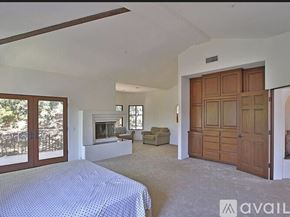 Westlake Village house for rent - A bedroom with a bed, a couch, and a fireplace.