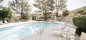 Oak Park condo for rent - A large outdoor swimming pool surrounded by lounge chairs and trees.