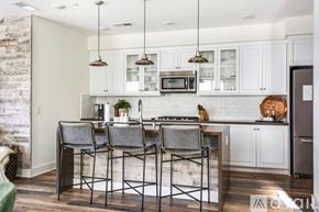 Encinitas house for rent - A kitchen with white cabinets and a brick wall.