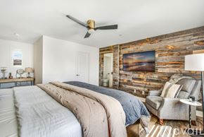 Encinitas house for rent - A bedroom with a large bed and a wooden wall.