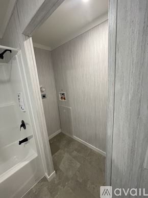 Andover house for rent - A bathroom with a white tub and grey tiles.