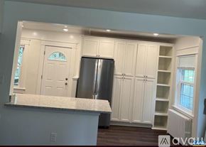 Charlottesville house for rent - A kitchen with white cabinets and a marble countertop.