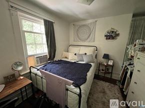 Charlottesville house for rent - A bedroom with a bed, nightstand, and window.