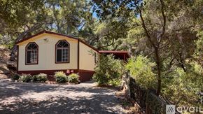 Topanga apartment for rent - A small house is surrounded by trees and a dirt path leads to it.