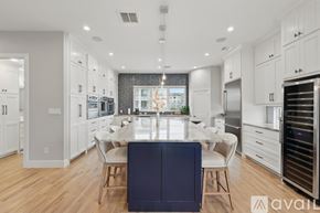 Flower Mound townhouse for rent - A modern kitchen with a dining table and chairs in the center.