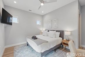 Flower Mound townhouse for rent - A bedroom with a large bed and a television mounted on the wall.