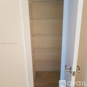 Miami apartment for rent - A glass wall separates two office spaces, one with a whiteboard and the other with a desk and chairs.