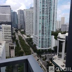 Miami apartment for rent - A cityscape with a tall building in the center and a street below.
