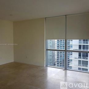 Miami apartment for rent - A large swimming pool surrounded by palm trees and lounge chairs.