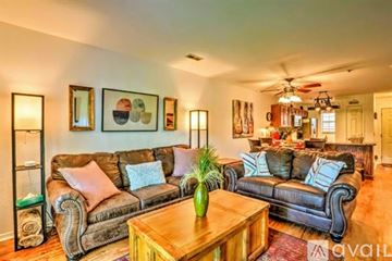 Branson apartment for rent - A living room with a brown leather couch and a wooden coffee table.