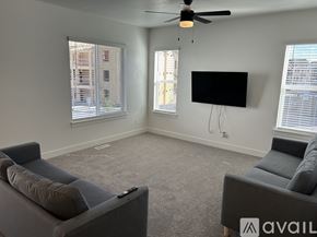 Lehi apartment for rent - A living room with grey couches and a flat screen TV mounted on the wall.