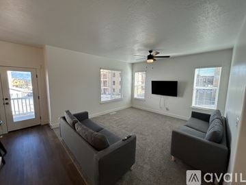 Lehi townhouse for rent - A living room with a grey couch and a television mounted on the wall.