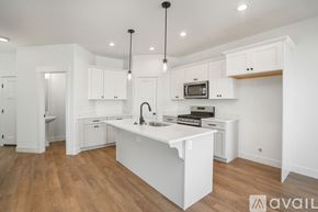 Lehi townhouse for rent - A kitchen with white cabinets and a white island.