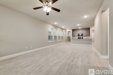 Forney house for rent - A spacious living room with a ceiling fan and lighting fixture.