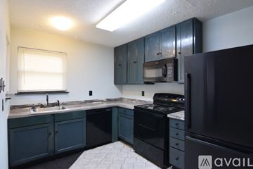 Temple apartment for rent - A kitchen with dark blue cabinets and a black refrigerator.