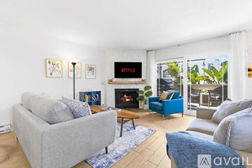 Imperial Beach condo for rent - A living room with a grey couch and a blue and white rug.
