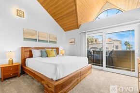 Imperial Beach condo for rent - A modern kitchen with a black refrigerator and wooden flooring.