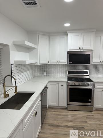 Dallas house for rent - A kitchen with white cabinets and a black oven.