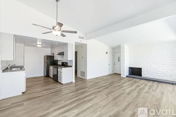 Yucca Valley apartment for rent - A spacious living room with a fireplace and a kitchen area in the background.