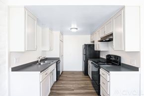 Yucca Valley apartment for rent - A kitchen with black appliances and white cabinets.