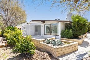 Yucca Valley apartment for rent - A house with a white exterior and a garden in front.