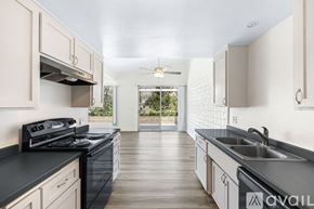 Yucca Valley apartment for rent - A kitchen with black countertops and white cabinets.
