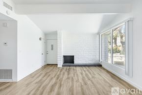 Yucca Valley apartment for rent - A spacious living room with a fireplace and wooden flooring.