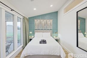 Mckinney house for rent - A bedroom with a large bed and a mirror on the wall.