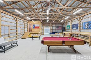 Mckinney house for rent - A billiards room with a pool table and flags on the wall.