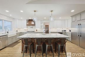 Mckinney house for rent - A kitchen with a marble table and stainless steel appliances.